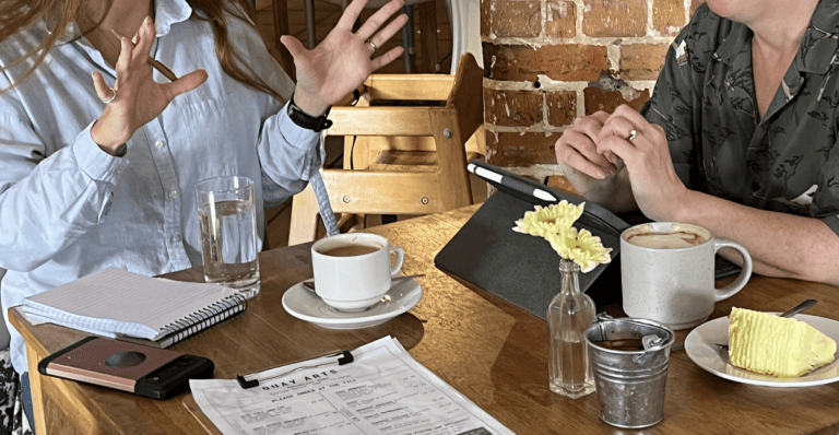 two people talking in a cafe focusing on the table and their hands