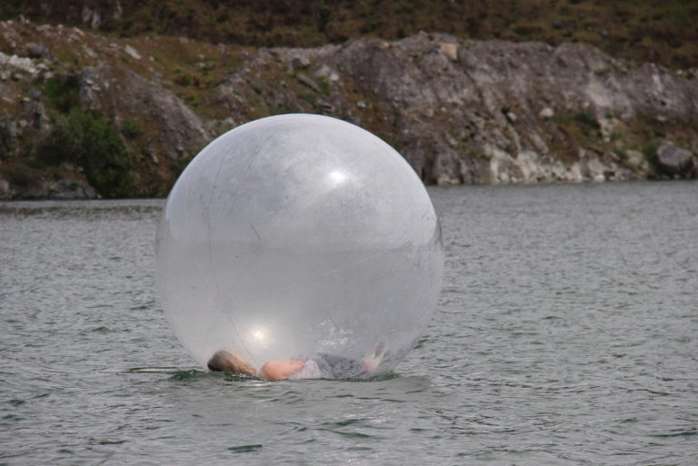 Woman floating in a giant bubble on water