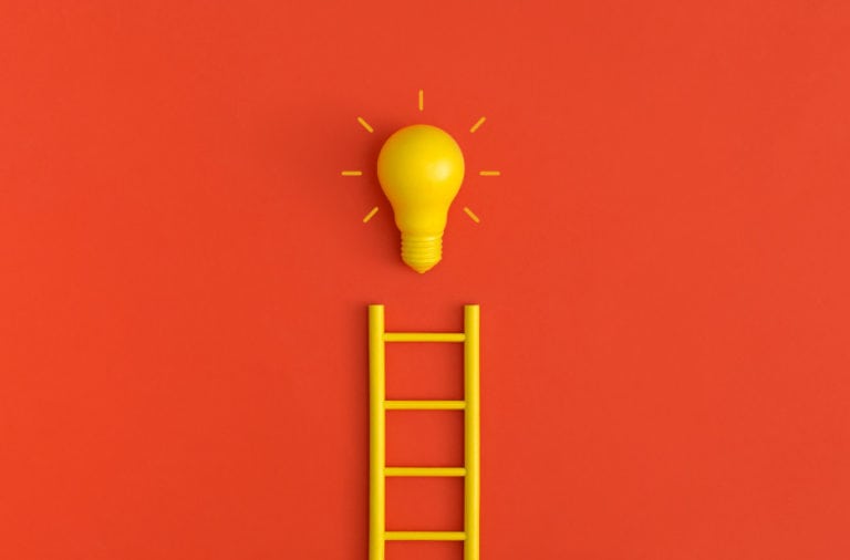 yellow lightbulb and ladder on a red background